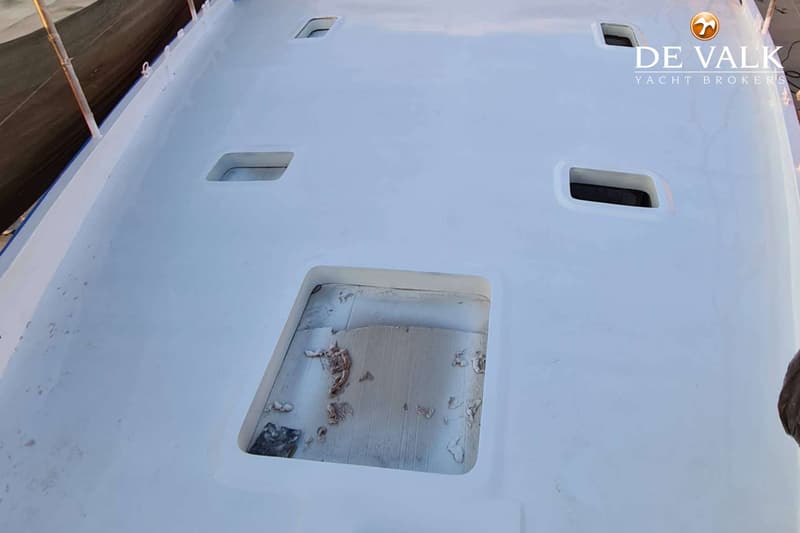 Het witte dek van een boot met vier rechthoekige openingen en een logo van "DE VALK YACHT BROKERS". — Suncoast 48