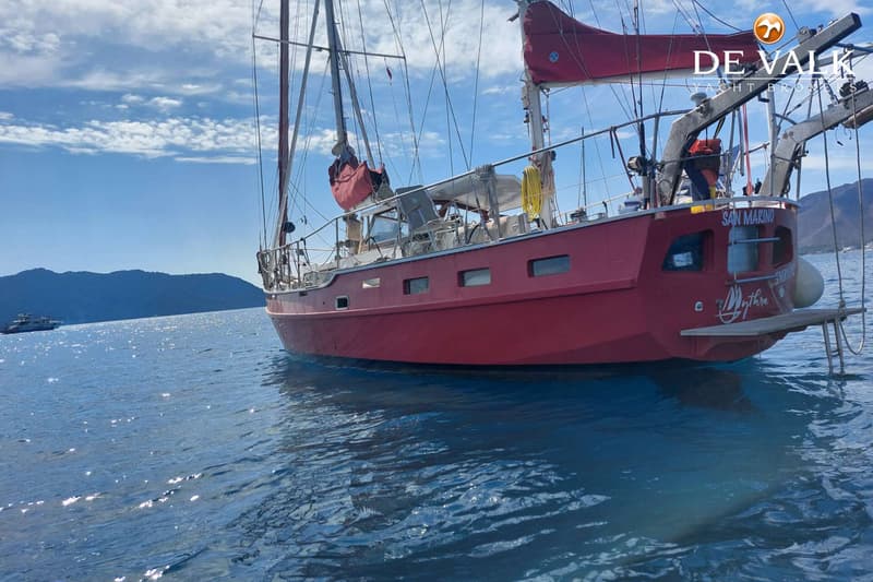 Een rode zeilboot met de naam "SAN MARINO" en "Mythra" op de spiegel, ligt op helderblauw water. — Suncoast 48