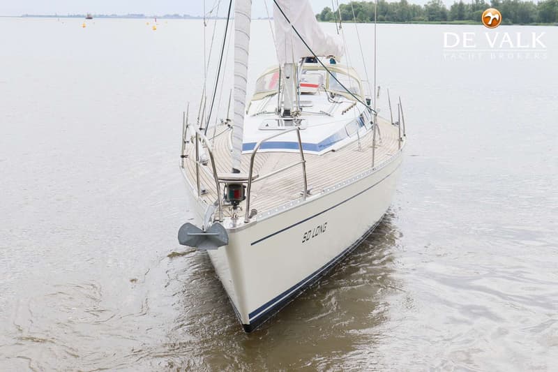 Een witte zeilboot met de naam "SO LONG" op de boeg ligt in het water. — Faurby 396