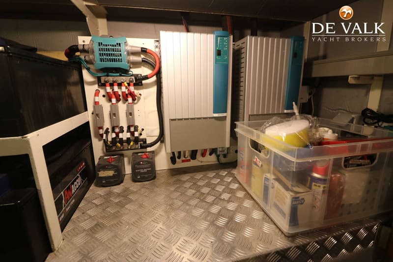 De foto toont een technische ruimte met elektrische installaties, waaronder een Mastervolt omvormer, accu's en een…