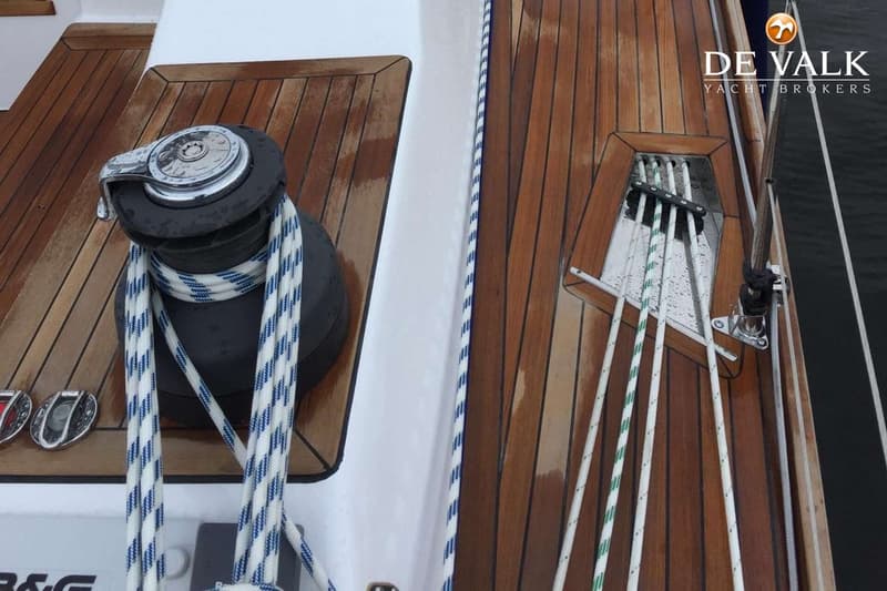 Een interieur van een boot met houten wanden en vloer, twee bedden met blauwe kussens en een trapje. — Nordbaelt 50
