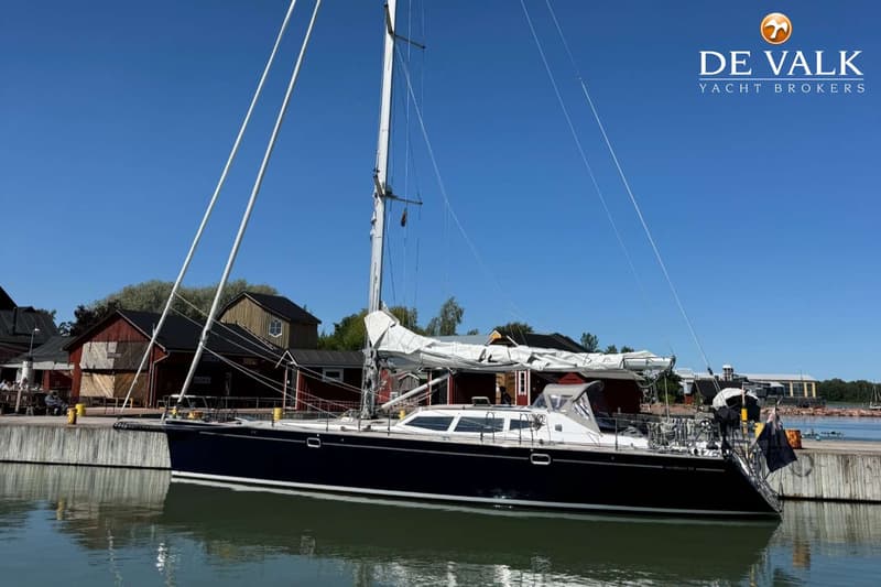 Een bovenaanzicht van het teakhouten dek van een boot met een lier, touwen, een kompas en een stootwil. — Nordbaelt 50