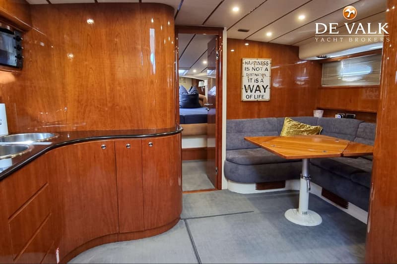 De foto toont een interieur van een boot met een kombuis, zithoek, en een doorgang naar een slaapvertrek. — Conam 58 Sport HT