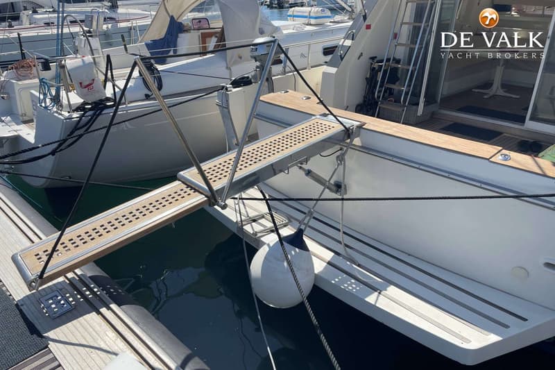 Een loopplank met houten latten en metalen randen verbindt de kade met de achtersteven van een boot. — Guy Couach 1501 Fly