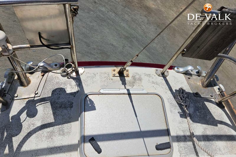 Een bovenaanzicht van een deel van het dek van een boot met een luik, diverse beslag en touwen. — Rorqual NS 44 Ketch