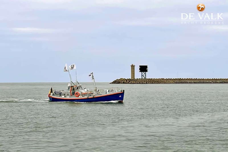 Een blauw-witte boot met oranje accenten vaart op het water, met een vlag met een '9' erop en een Belgische vlag.