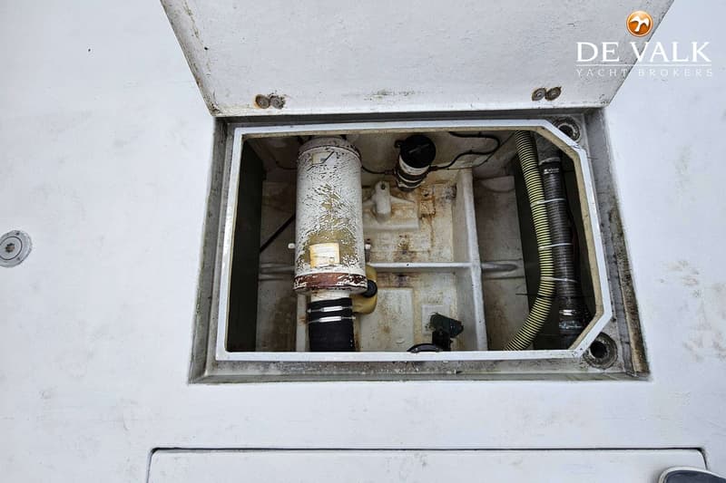 Een open luik toont een compartiment met een verticale tank, slangen en bedrading.