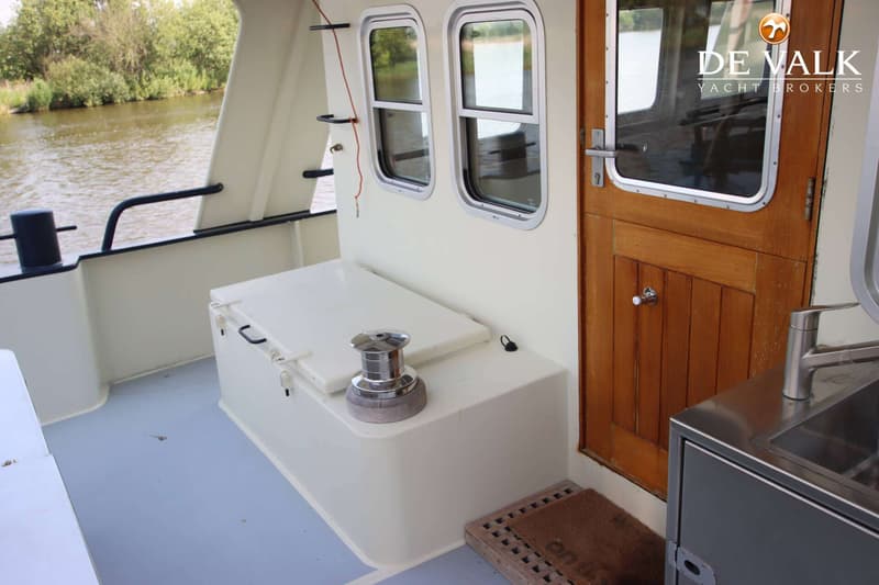 Een dek van een boot met een houten deur, twee ramen, een lier en een gootsteen met kraan. — Bekebrede 1800 Explorer Trawler