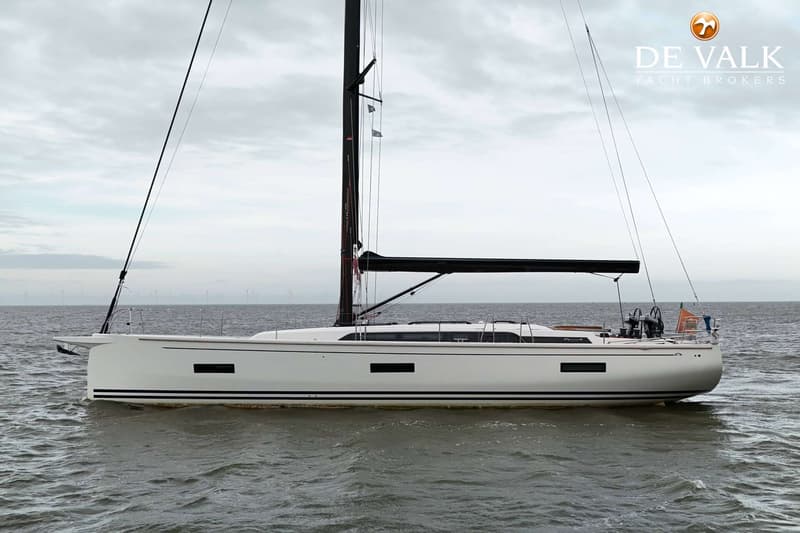 Een witte zeilboot met een zwarte mast en giek vaart op grijs water onder een bewolkte hemel. — Arcona 50
