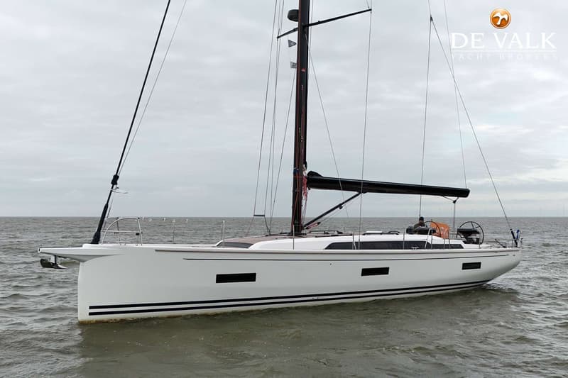 Een witte zeilboot met zwarte strepen op de romp vaart op een grijze zee onder een bewolkte lucht. — Arcona 50