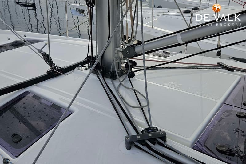 Een close-up van het dek van een zeilboot met de mast, giek, lijnen, lieren en luiken. — Jeanneau Sun Odyssey 440