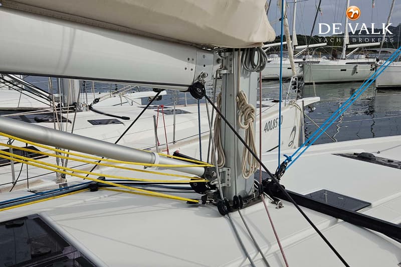 Een close-up van de mastvoet en giek van een zeilboot, met diverse lijnen en blokken. — Jeanneau Sun Odyssey 490