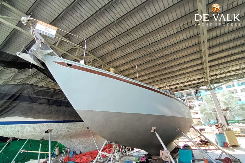 Een zeilboot staat op bokken in een loods, met een "FOR SALE" bordje aan de boeg. — Frans Maas Calypso 43