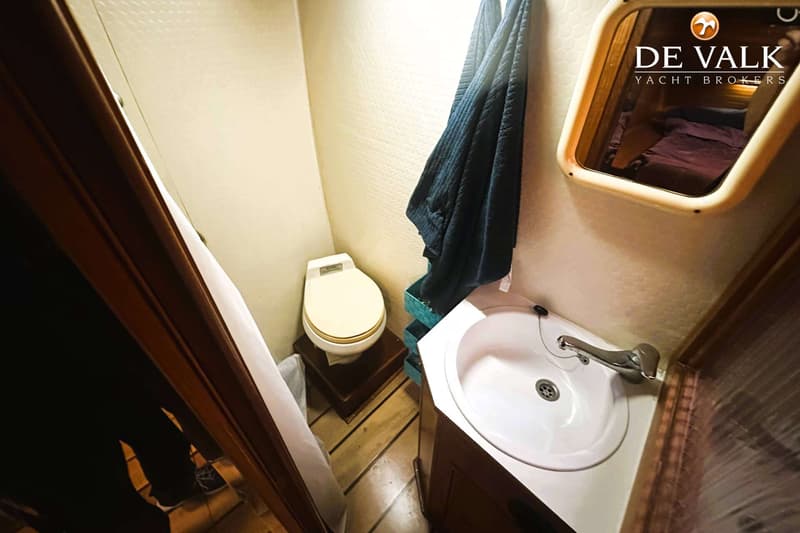 Een kleine badkamer met een toilet, wastafel, spiegel en een handdoek.