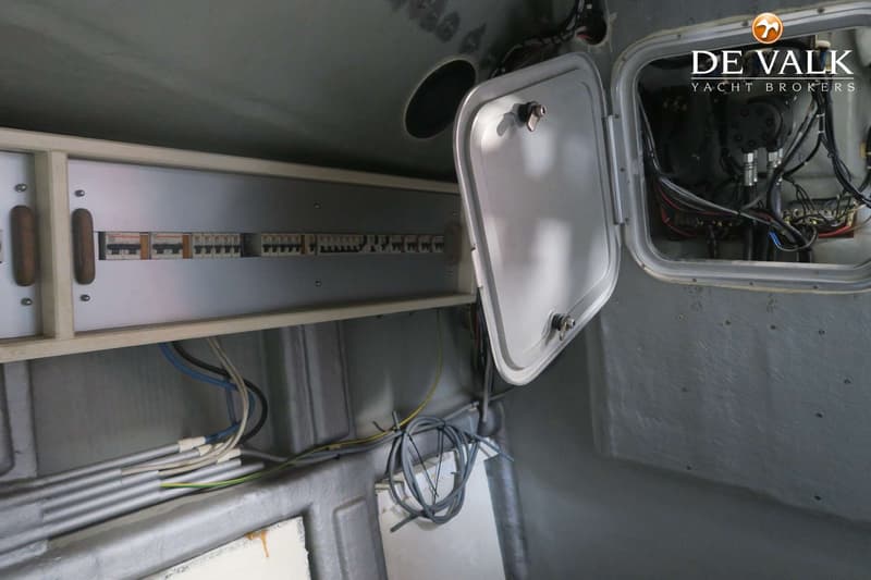 Een detailfoto van een elektrische installatie met een open paneel en diverse kabels.