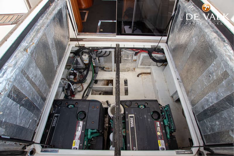 Twee zwarte Volvo Penta motoren zijn zichtbaar in een open motorruimte met isolatiemateriaal aan de binnenzijde van de…