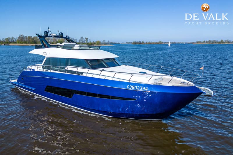 Een blauw-witte motorboot met registratienummer 03802394 vaart op een meer onder een heldere blauwe lucht.