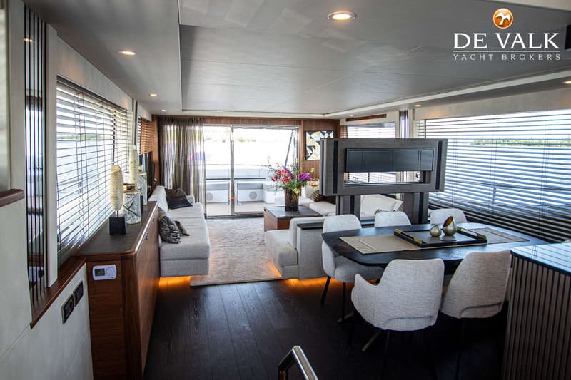 Een ruime, moderne woonkamer op een boot met een zithoek, eettafel en uitzicht naar buiten. — Van der Heijden Phantom 80