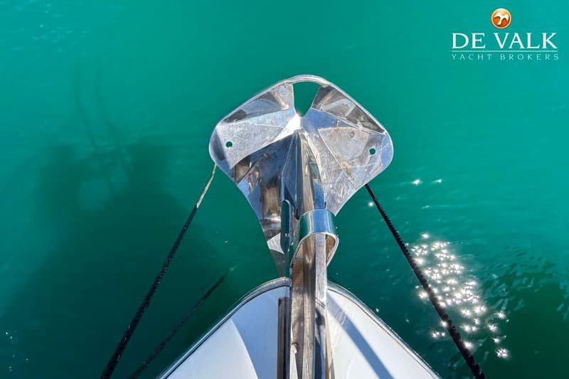 De boeg van een boot met een ankerrol en twee zwarte touwen die in het turquoise water verdwijnen. — Sunseeker Portofino 53