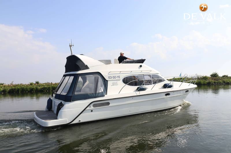 Een witte motorboot met een man aan het roer vaart op een waterweg, met een kenteken 63-50-YE op de zijkant. — Galeon 380 Fly