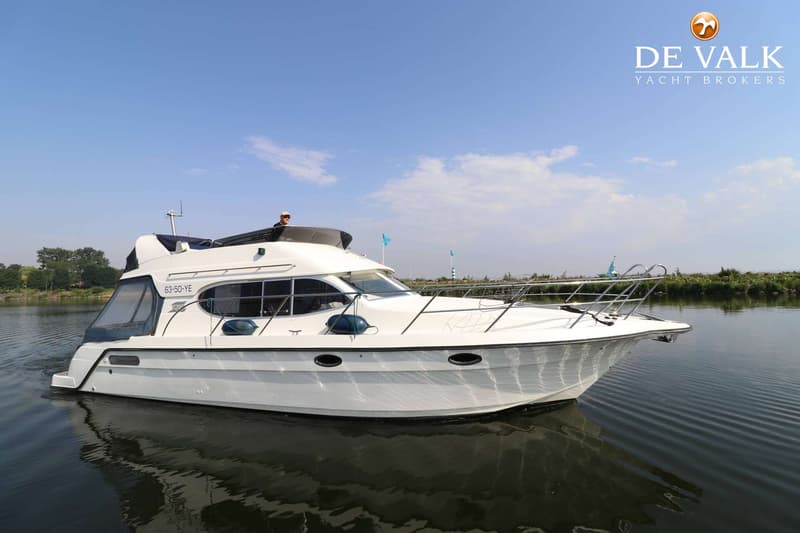 Een witte motorboot met registratienummer 63-50-YE vaart op rustig water onder een blauwe lucht met enkele wolken.