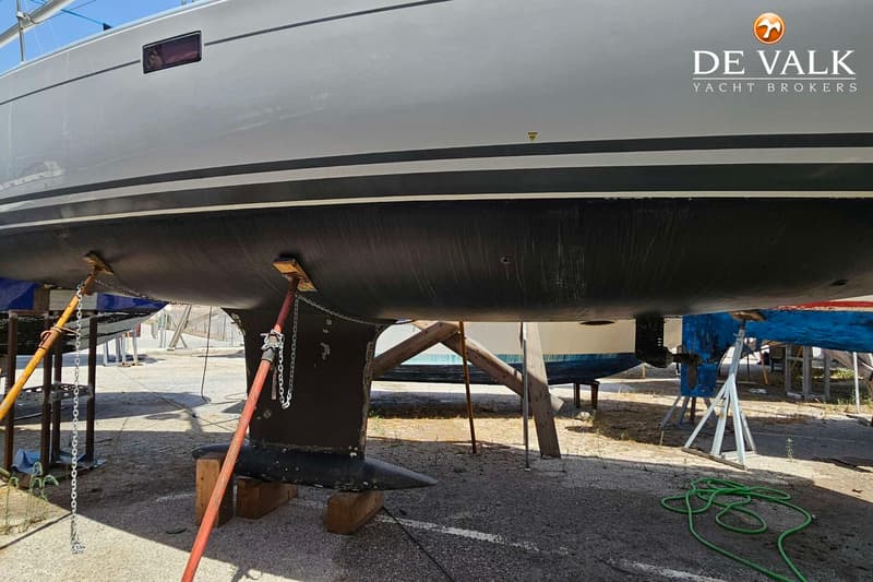 Een witte boot met een zwarte onderkant staat op de wal, ondersteund door stutten en kettingen. — Hanse 350