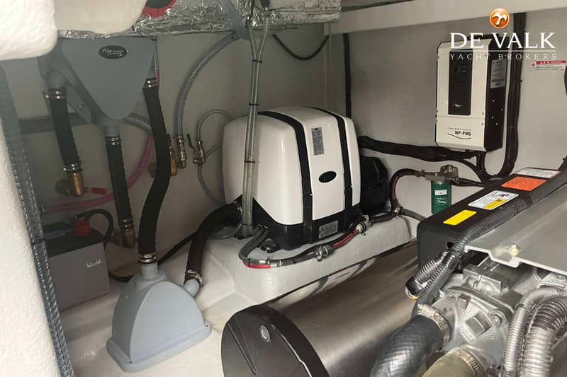 Een detailfoto van een motorruimte met diverse apparatuur, slangen en bedrading.