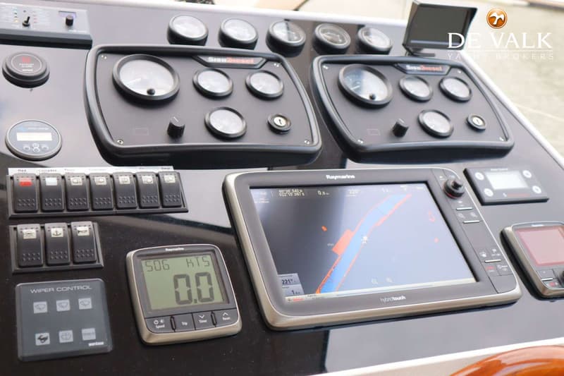 Een close-up van een dashboard met diverse meters, schakelaars, een Raymarine kaartplotter en een snelheidsmeter.