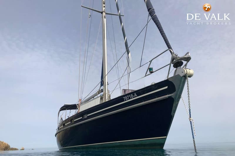 Een donkerblauwe zeilboot met witte strepen en de registratie "78718-A" ligt in het water. — Contest 43/44