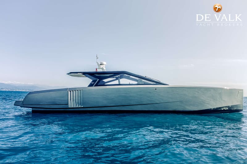 Een moderne, grijze motorboot met een donkerblauwe opbouw en getinte ramen vaart op helderblauw water. — Wally WallyPower58