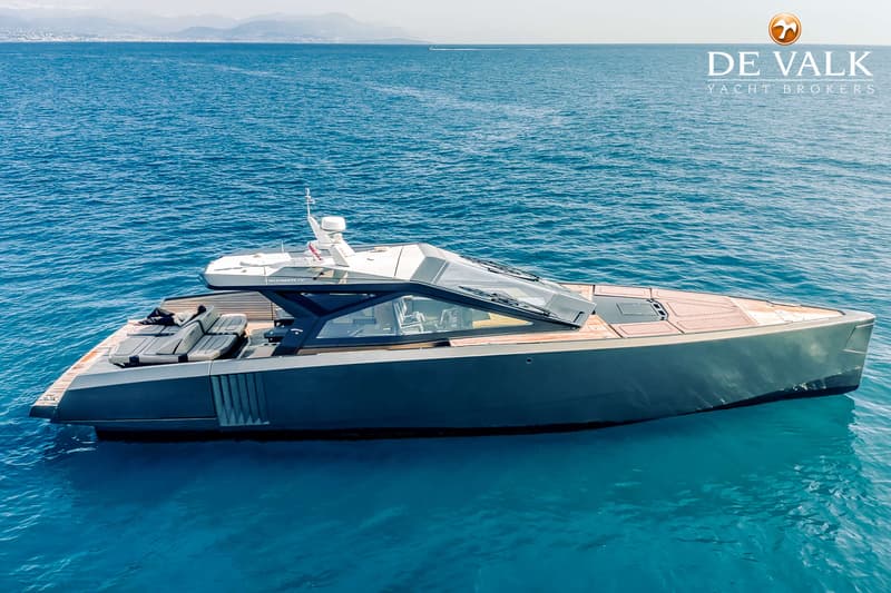 Een donkergrijze motorboot met een houten dek en een glazen opbouw drijft op helderblauw water. — Wally WallyPower58