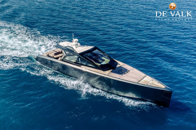 Een donkergrijze motorboot met een houten dek en een glazen opbouw vaart over blauw water. — Wally WallyPower58