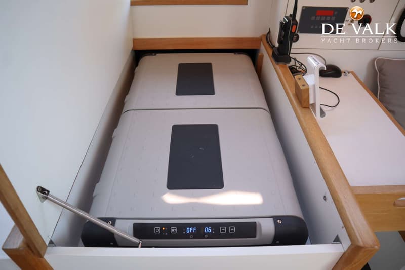 Twee grijze koelboxen met digitale displays zijn zichtbaar in een witte opbergruimte met houten accenten.