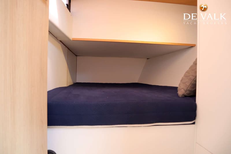 De foto toont een kajuit met een donkerblauw matras, een kussen en een houten plank erboven. — Berckemeyer 43