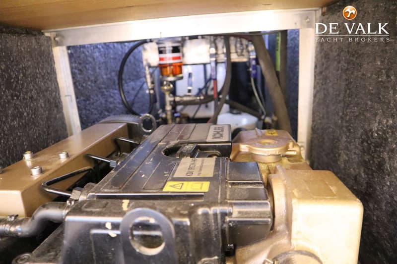 Een close-up van een motorruimte met een Kohler-motor en diverse leidingen en filters.
