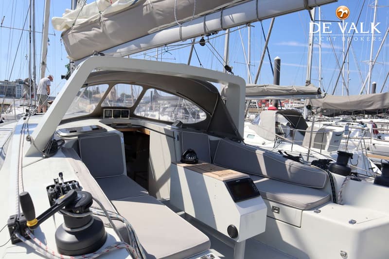 De foto toont de kuip van een zeilboot met grijze kussens, een stuurstand, lieren en een kompas. — Berckemeyer 43