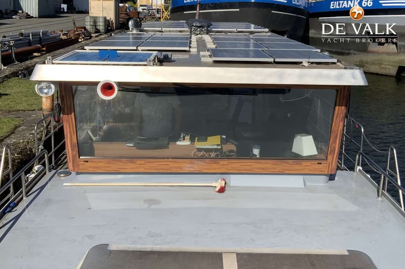 De foto toont de bovenkant van een boot met zonnepanelen op het dak en een stuurhut met grote ramen. — Luxe motor 22 m