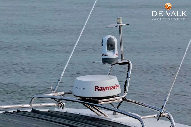 Een witte Raymarine radar en een witte bewakingscamera zijn gemonteerd op een roestvrijstalen beugel op een boot.