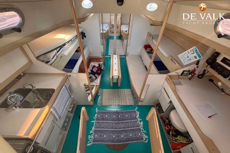 Een interieur van een boot met een kombuis, slaapplaatsen, een tafel en een navigatiehoek. — Hutting 40