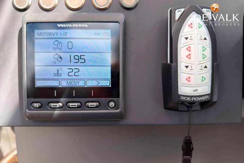 Een Volvo Penta motordisplay toont 0 RPM, 195 draaiuren en een temperatuur van 22°C, naast een Side-Power afstandsbediening.