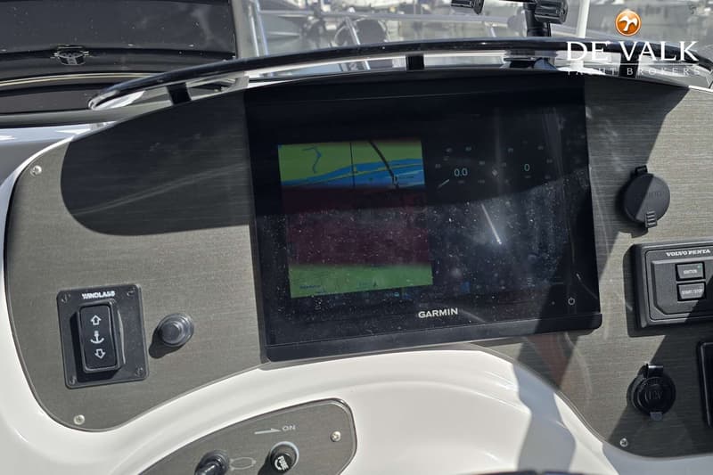 Een Garmin-scherm met navigatiekaart en snelheidsmeter, een Windlass-schakelaar en een Volvo Penta start/stop-paneel zijn…