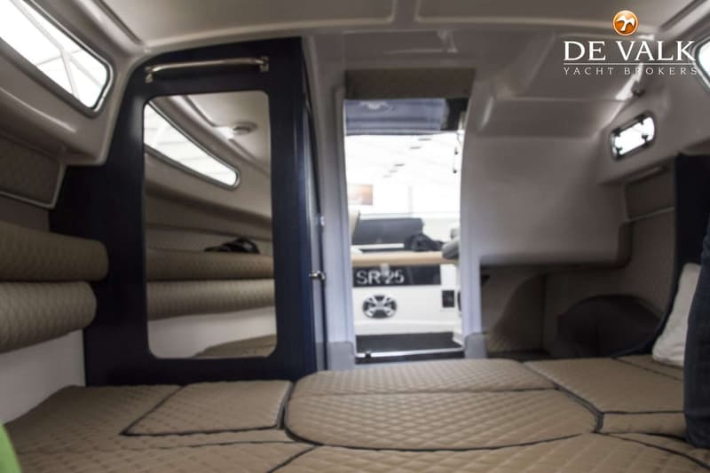 De foto toont het interieur van een boot met een bed, een spiegel en een doorgang naar een ander gedeelte. — Öchsner SR 25