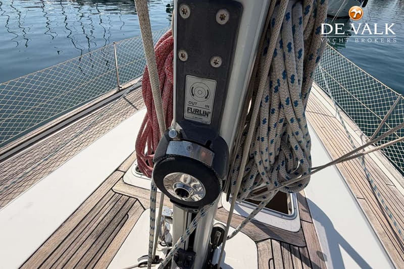 Een detailfoto van een mast met een Furlin oprolsysteem, diverse lijnen en een teak dek.