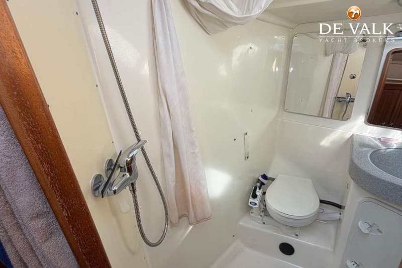 De foto toont een badkamer met een douche, toilet en wastafel.