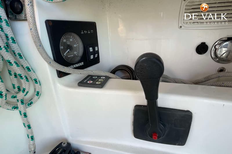 Een detailfoto van een bootinterieur met een Yanmar toerenteller, een Side-Power afstandsbediening en een gashendel.