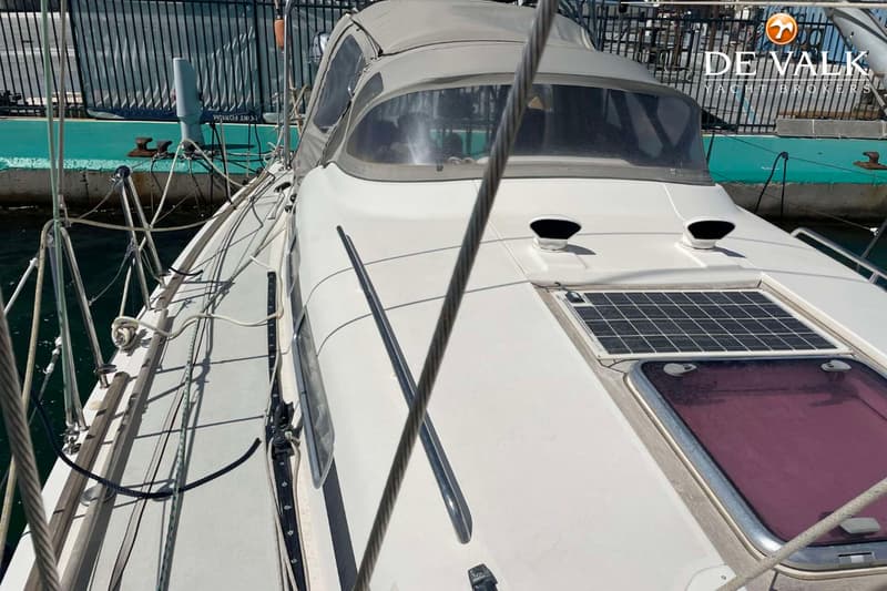 Een bovenaanzicht van een witte boot met een grijze buiskap, zonnepaneel en twee ventilatieopeningen. — Arcona 430