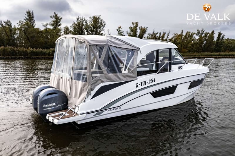 Een witte motorboot met twee Yamaha buitenboordmotoren en een beige cabriokap ligt in het water. — Beneteau Antares Serie 9