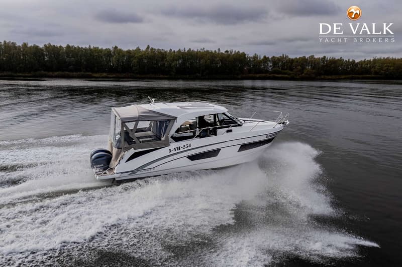 Een witte motorboot met registratienummer 5-YH-254 vaart op het water, met een bosrijke oever op de achtergrond.