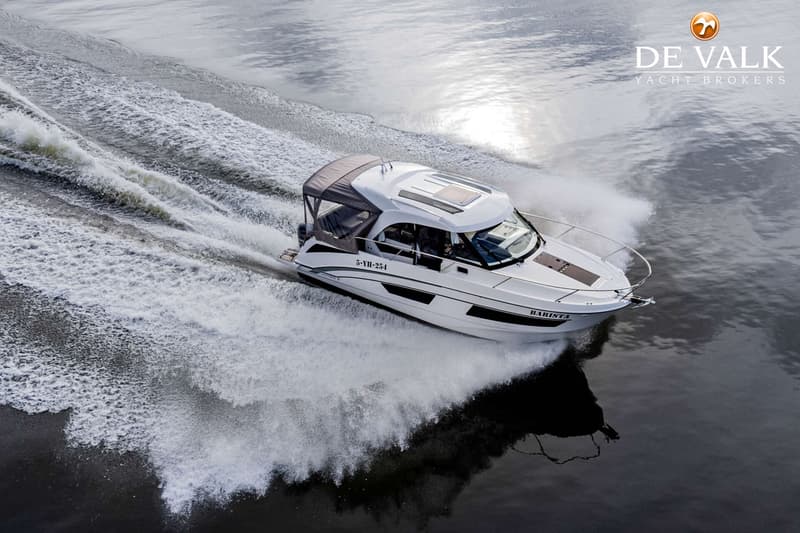 Een witte motorboot met de naam "BARISTA" en registratienummer "5-YH-254" vaart over water, spattend aan de zijkanten.