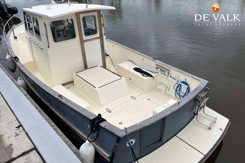 Een boot met een kajuit en een open achterdek ligt aangemeerd aan een steiger. — Rhea Marine 750